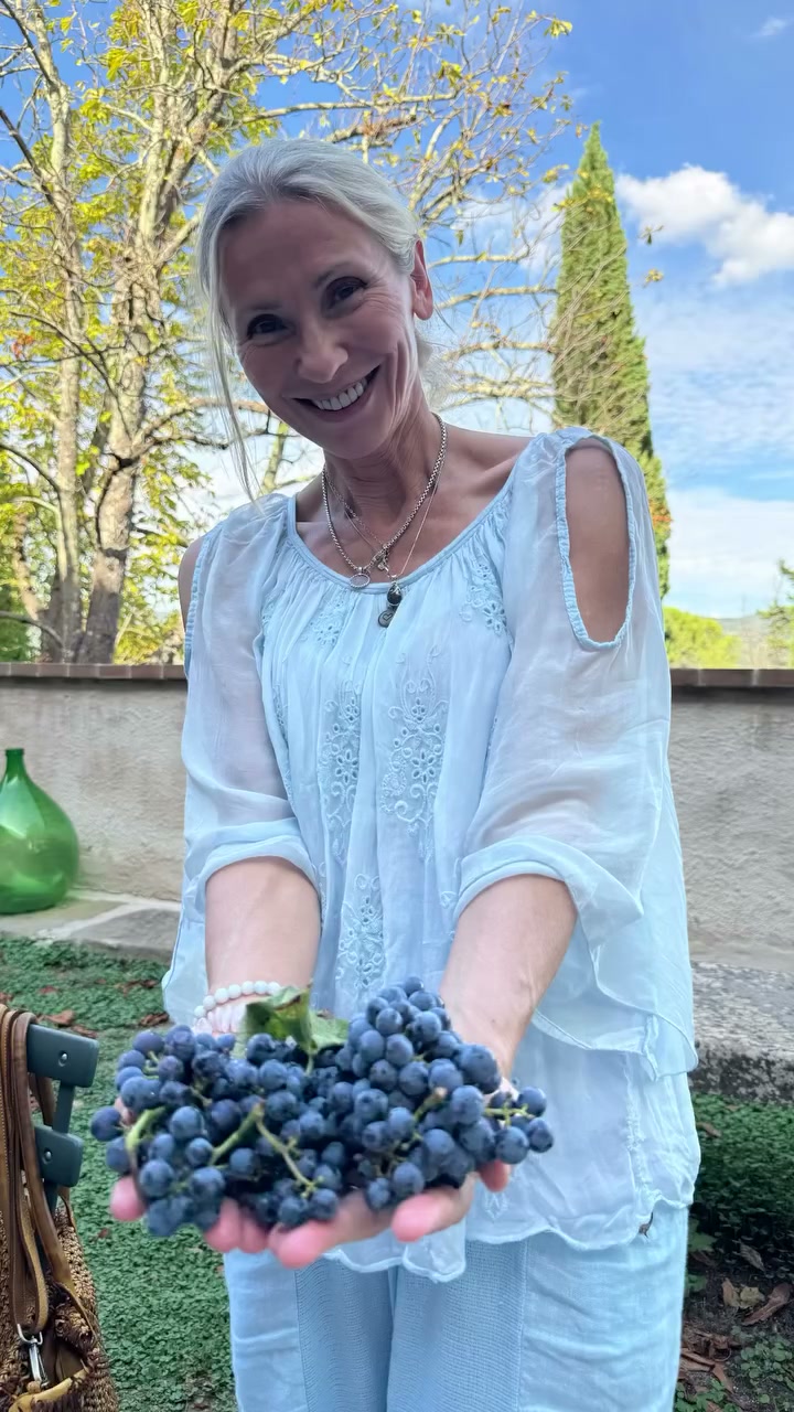 Elvira holding a bunch of grapes in Umbria